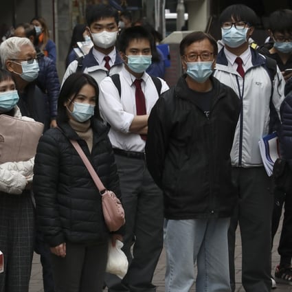 Pedestrians wait to cross the street on January 19, as Hong Kong battles a fourth wave of the coronavirus disease. Even as an upcoming mass vaccination programme offers hope, significant public reluctance remains a problem. Photo: Jonathan Wong