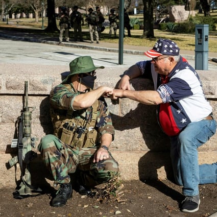 A member of an armed group and a Trump supporter meet during a rally in front of the closed Texas State Capitol in Austin, on January 17, amid unfounded claims of election fraud. Arguably, the first casualty of the Trump years has been trust. Photo: AFP