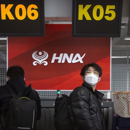 Travellers wearing face masks to protect against the spread of the coronavirus wait in line at the Hainan Airlines check-in counters at Beijing Capital International Airport in Beijing on March 6, 2020. Photo: AP
