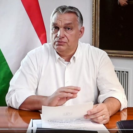 Hungarian Prime Minister Viktor Orban is seen on a laptop screen during a coronavirus announcement. Photo: AFP
