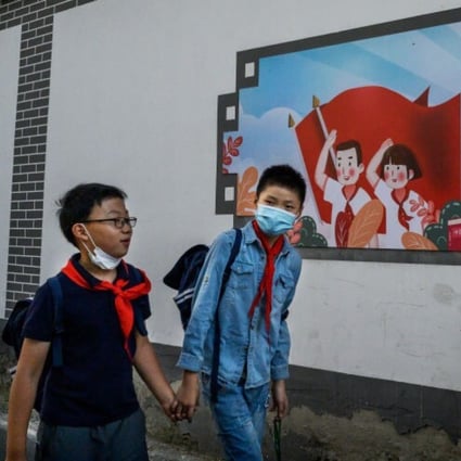 Chinese boys walk home together hand in hand from a local junior school in Beijing, China. Photo: Getty Images
