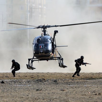 Indian army solders disembark a helicopter while performing an operation demonstration. Photo: Bloomberg