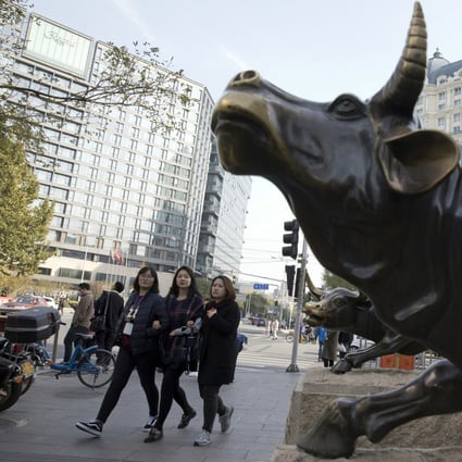 Pedestrians walk past a statue of a bull in Beijing. Alibaba recouped earlier slump to help the Hang Seng Index to a third day of gains on February 3, 2021. Photo: AP