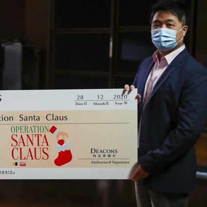 SCMP Charities Ltd project director Lawrence Wong (right) receives a cheque from DEACONS official Lilian Chiang in Kowloon Tong. Photo: Edmond So
