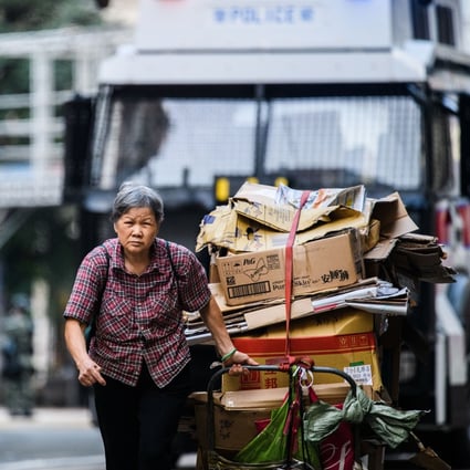 An elderly woman drags a trolley load of cardboard for recycling in Hong Kong on November 2, 2019. Photo: AFP