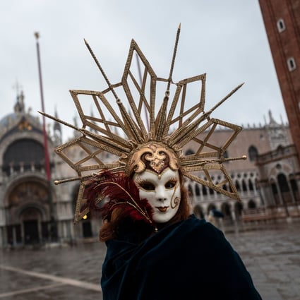 A Venetian wearing a carnival mask and costume at St Mark's square in Venice on Sunday. Photo: AFP