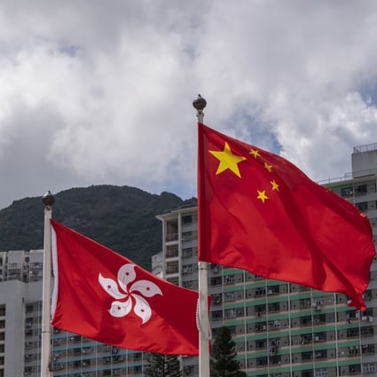 The Hong Kong and Chinese flags fly against a backdrop of highrise buildings and Lion’s Rock mountain, in Wong Tai Sin district of Hong Kong. Photo: Sun Yeung