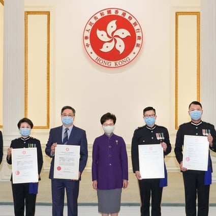 Chief Executive Carrie Lam hands awards to seven serving and retired police leaders in recognition of their public service. Photo: SCMP