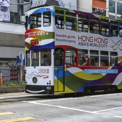 Closed or struggling shops form the backdrop as a tram advertising Hong Kong as “Asia’s World City” stops at a red light in Causeway Bay, one of the city’s major commercial districts. Photo: Nora Tam