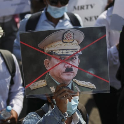 A protester holds up a defaced portrait of junta chief General Min Aung Hlaing at a rally against the military coup in Naypyidaw on Thursday. Photo: EPA