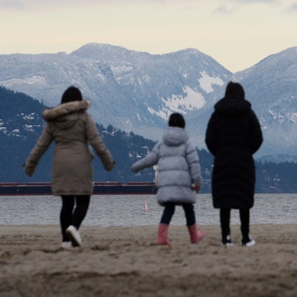 A family of Hong Kong immigrants walk along Jericho Beach in Vancouver, British Columbia on January 26. Photo: Reuters