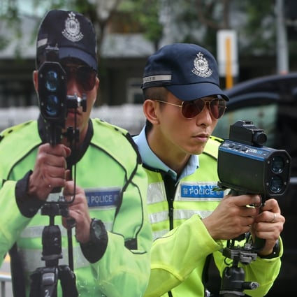 A Hong Kong police sergeant poses with a speed gun next to a cutout of an officer to be placed by the roadside as a reminder to drivers, in Tuen Mun in August 2012. Photo: Sam Tsang