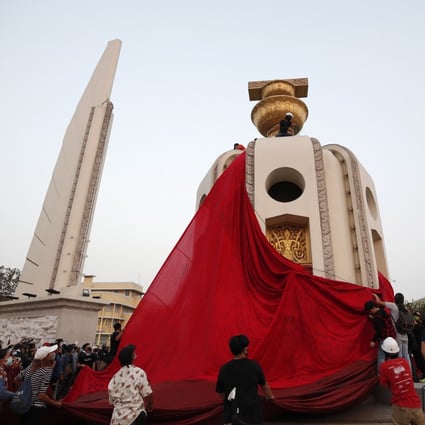 Anti-government protesters cover the Democracy Monument with a crimson cloth during a rally in Bangkok on Saturday. Photo: EPA-EFE