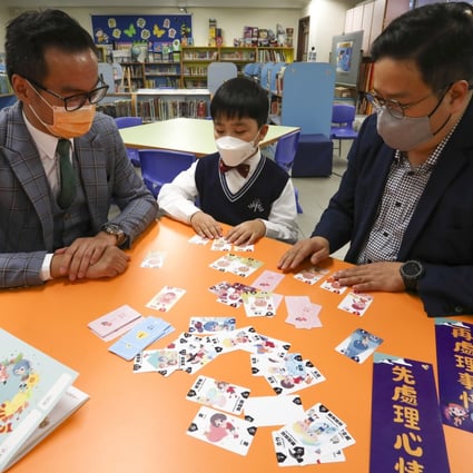 (Left to right) School principal Kwok Chiu-kwan, student Colin Choi and his father, Michael Choi, use flash cards developed by Just Feel. Photo: Jonathan Wong