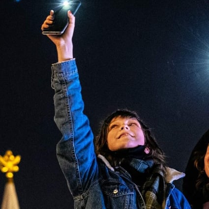 Navalny supporters flash their mobile phone lights near Red Square in Moscow on Sunday. Photo: AFP