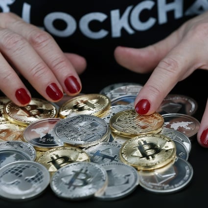 In this photo illustration, a woman shows different visual representations of cryptocurrencies, Ripple, Bitcoin, Litecoin and Ethereum on February 01, 2018 in Paris, France. Photo: Getty Images