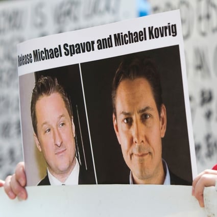 A supporter holds a picture of Michael Spavor (left) and Michael Kovrig, who have been detained in China for more than two years. Photo: AFP
