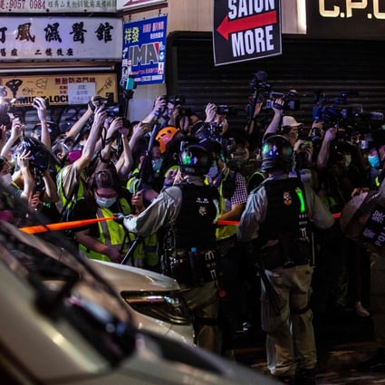 Hong Kong police hold back members of the press during an operation to arrest pro-democracy demonstrators in Mong Kok on May 10, 2020. Photo: AFP