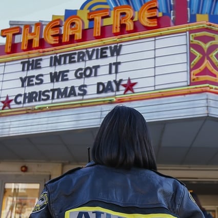 An off-duty police officer hired by the cinema stands watch as people arrive to watch the controversial movie The Interview at the Plaza Theatre in Atlanta, Georgia, in December 2014. The Sony Pictures comedy was the subject of threats by North Korea after a hacking attack. Photo: EPA