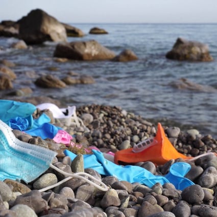 Single-use masks and used latex gloves litter a beach. Photo: Shutterstock