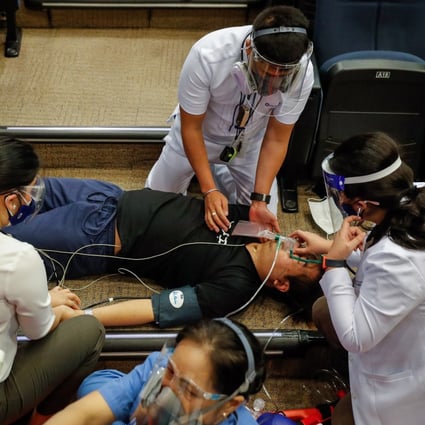 Health workers attend to a man faking an adverse reaction to a vaccine during a practice drill at a hospital in Metro Manila on Thursday. The Philippines has struggled to make a start on its inoculation programme. Photo: EPA-EFE