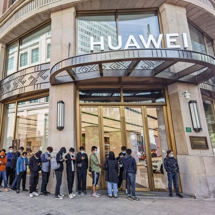 People wait in line in front of Huawei's flagship store for presales of the newly launched Huawei Mate40 mobile phone series in Shanghai, China, on October 23, 2020. Photo: AFP