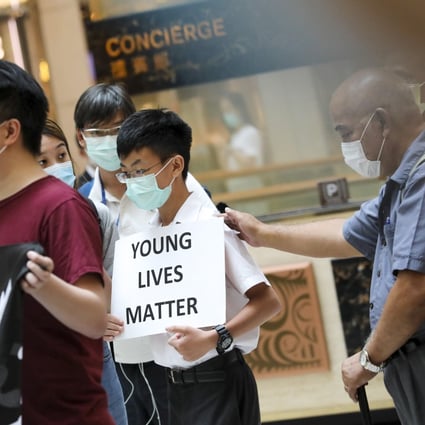 A teenager carries a placard saying “Young Lives Matter” at a peaceful lunchtime demonstration at Landmark mall in Central district of Hong Kong, on June 9, 2020. Photo: K.Y. Cheng