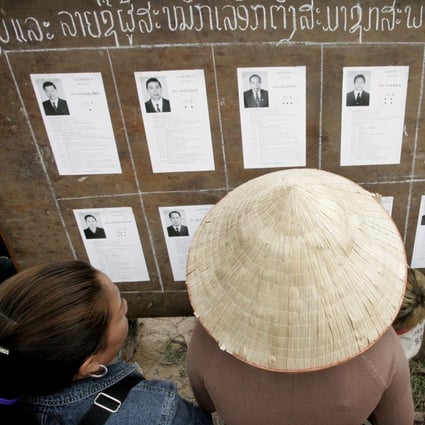 Laotians look at candidates’ pictures at a polling station during the general election in 2006. Photo: Reuters
