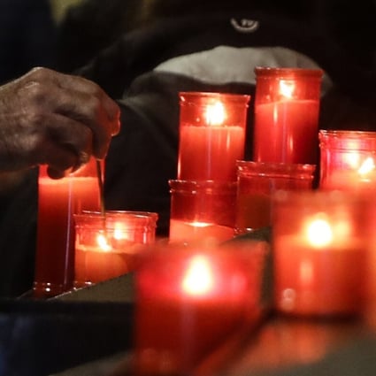A man lights a candle during a Mass at the San Biagio church in Codogno, northern Italy on Sunday. Photo: AP