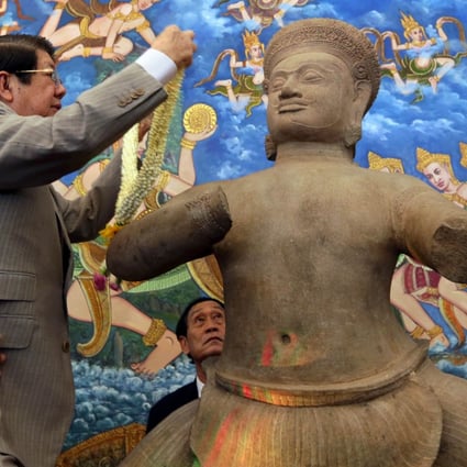 A 10th-century statue is presented at a 2014 ceremony in Phnom Penh, one of three works welcomed home four decades after they were looted from the country in the 1970s. Photo: AFP