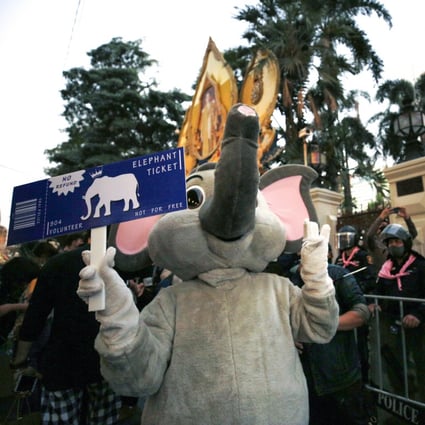An anti-government protester wearing an elephant costume flashes the pro-democracy movement’s three-finger salute next to a line of anti-riot police officers at the Royal Thai Police Headquarters in Bangkok on Tuesday Photo: EPA-EFE