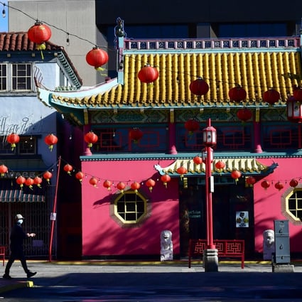 A pedestrian wearing a face mask walks across a deserted Chinatown Central Plaza in Los Angeles, where many businesses remain closed due to the coronavirus pandemic, on the first day of the Lunar New Year on February 12. Photo: AFP