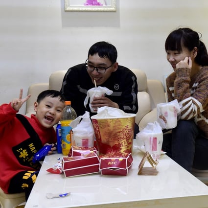 Li Hongqiang, 32, a delivery man for SF Express in Hefei, decided to stay put with his wife and son for the Lunar New Year holiday, heeding the state's call to curb the spread of Covid-19 with reduced travel. Photo: Xinhua