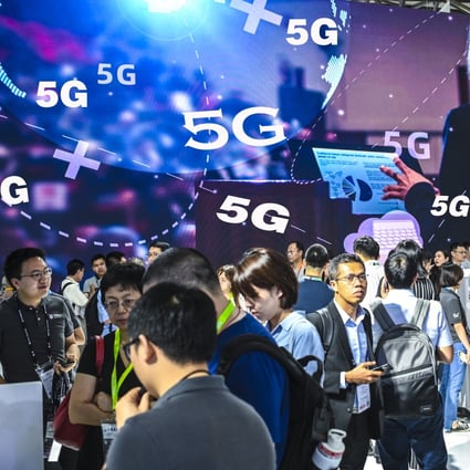 Visitors pass in front of a 5G advertisement during the MWC Shanghai trade show, held at Shanghai New International Expo Centre on June 27, 2019. Photo: Getty Images