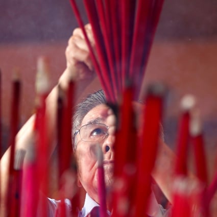 A man prays during Lunar New Year celebrations at a temple in Jakarta, Indonesia. Photo: Reuters