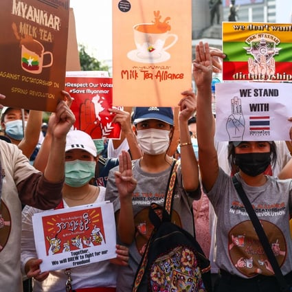 Pro-democracy protesters holds signs relating to the #MilkTeaAlliance and the current situation in Myanmar as they take part in a demonstration in Bangkok on Sunday. Photo: AFP