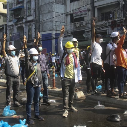 Protesters flash three-finger salutes during an anti-coup demonstration on a blocked road in Yangon, Myanmar. Photo: AP