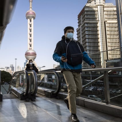 Pedestrians wearing protective masks ride on an escalator in Pudong's Lujiazui Financial District in Shanghai. Investors are looking to the “Two Sessions” in Beijing later this week for signs of further policy support: Photo: Bloomberg.