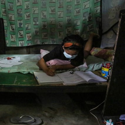 Filipino student Maria Fe Morallos does her schoolwork inside her home in an informal settlers area in Malabon City, suburban Manila. Photo: AFP