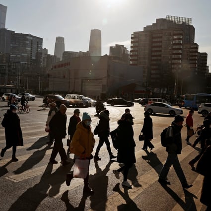 People cross a street during morning rush hour in Beijing’s central business district. Photo: Reuters