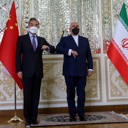China's Foreign Minister Wang Yi bumps elbows with his Iranian counterpart Mohammad Javad Zarif. Photo: Reuters
