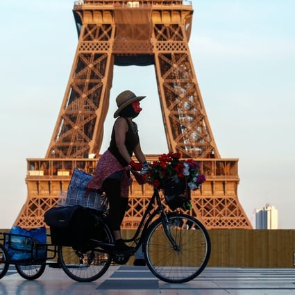 A woman rides her bicycle near the Eiffel Tower at Trocadero Square in Paris last month. Photo: Reuters