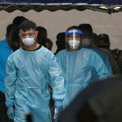 Personnel in protective gear usher a group of migrant workers onto a bus to a government quarantine facility after they tested positive for Covid-19 at Westlite Woodlands dormitory in Singapore. Photo: Reuters