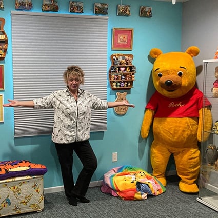 Collector Deb Hoffmann with a Winnie the Pooh costume used at Disney parks in the 1960s and 1970s (left), and one used in Sears stores during the 1970s and 1980s (right). Photo: TNS