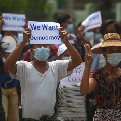 Demonstrators flash the three-finger salute and carry placards calling for democracy during an anti-military-coup protest in Mandalay, Myanmar, on April 26. Photo: EPA-EFE
