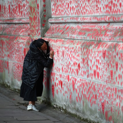 A woman writes a message on the National Covid Memorial Wall beside St Thomas’ Hospital in London on April 8. Hong Kong has lifted a flight ban from Britain, but still regards it as a “very high-risk” country. Photo: Reuters