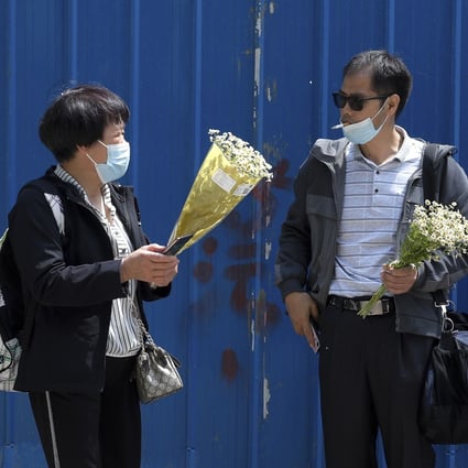 Chen Mei’s mother (left) and Cai Wei’s father with flowers given to them by the defendants’ supporters. Photo: AP