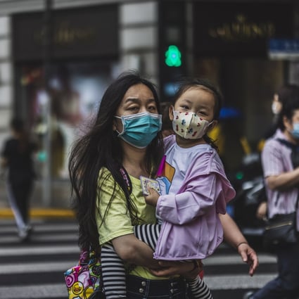 People cross the street in Shanghai on May 11. China must make a whole-of-society push to raise the birth rate, and this must include making childcare more accessible to working families. Photo: EPA-EFE