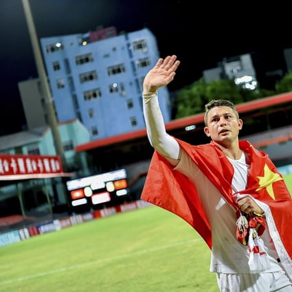 China's Brazilian-born forward Elkeson, also known as Ai Kesen, celebrates with a Chinese national flag at the end of the Qatar 2022 Fifa World Cup qualifying win over Maldives in September, 2019. Photo: AFP