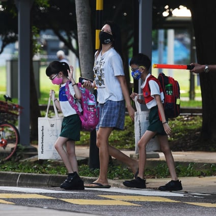 Primary school students wearing face masks make their way to school in Singapore. Photo: Xinhua